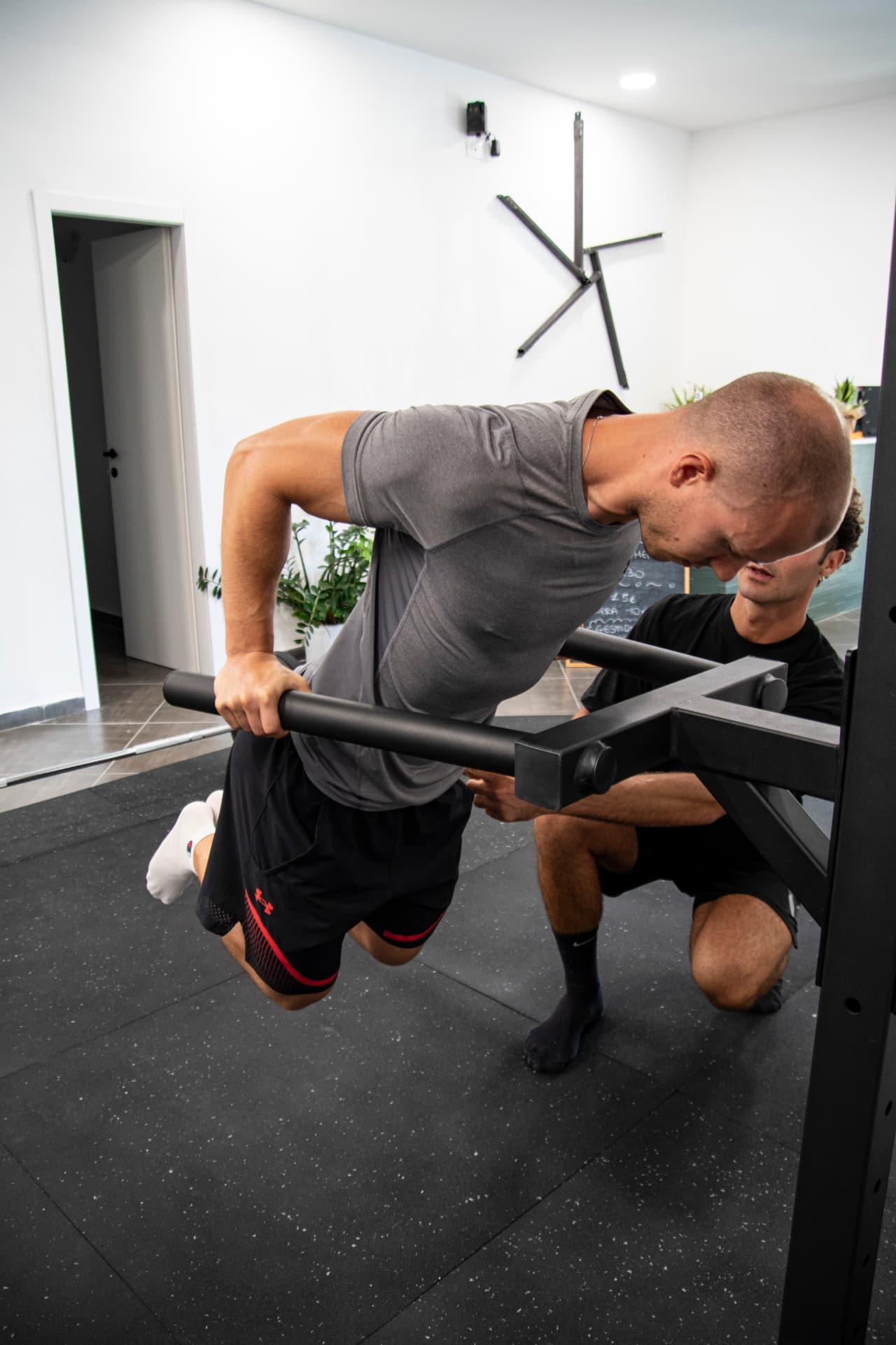 Trainer segue una persona durante un esercizio assistito nello studio